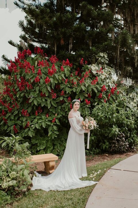 bride smiling in front of flowers at The Capen House
